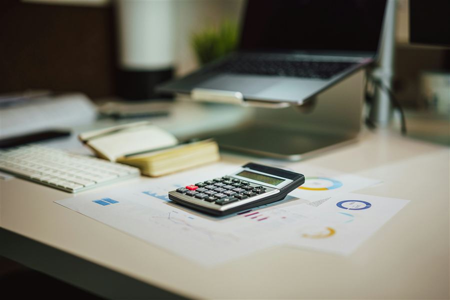 A calculator and laptop on an accountant's desk