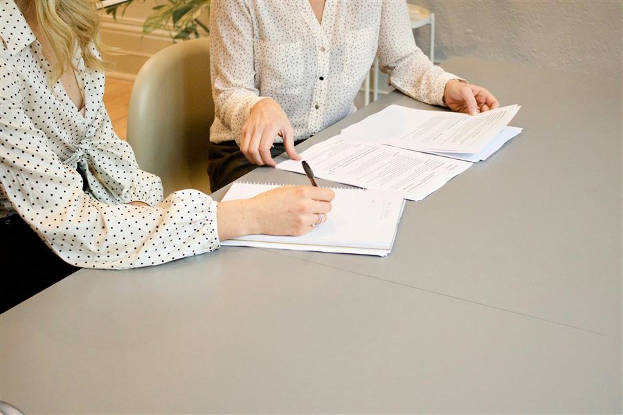 Two consultants reviewing paperwork together at a desk
