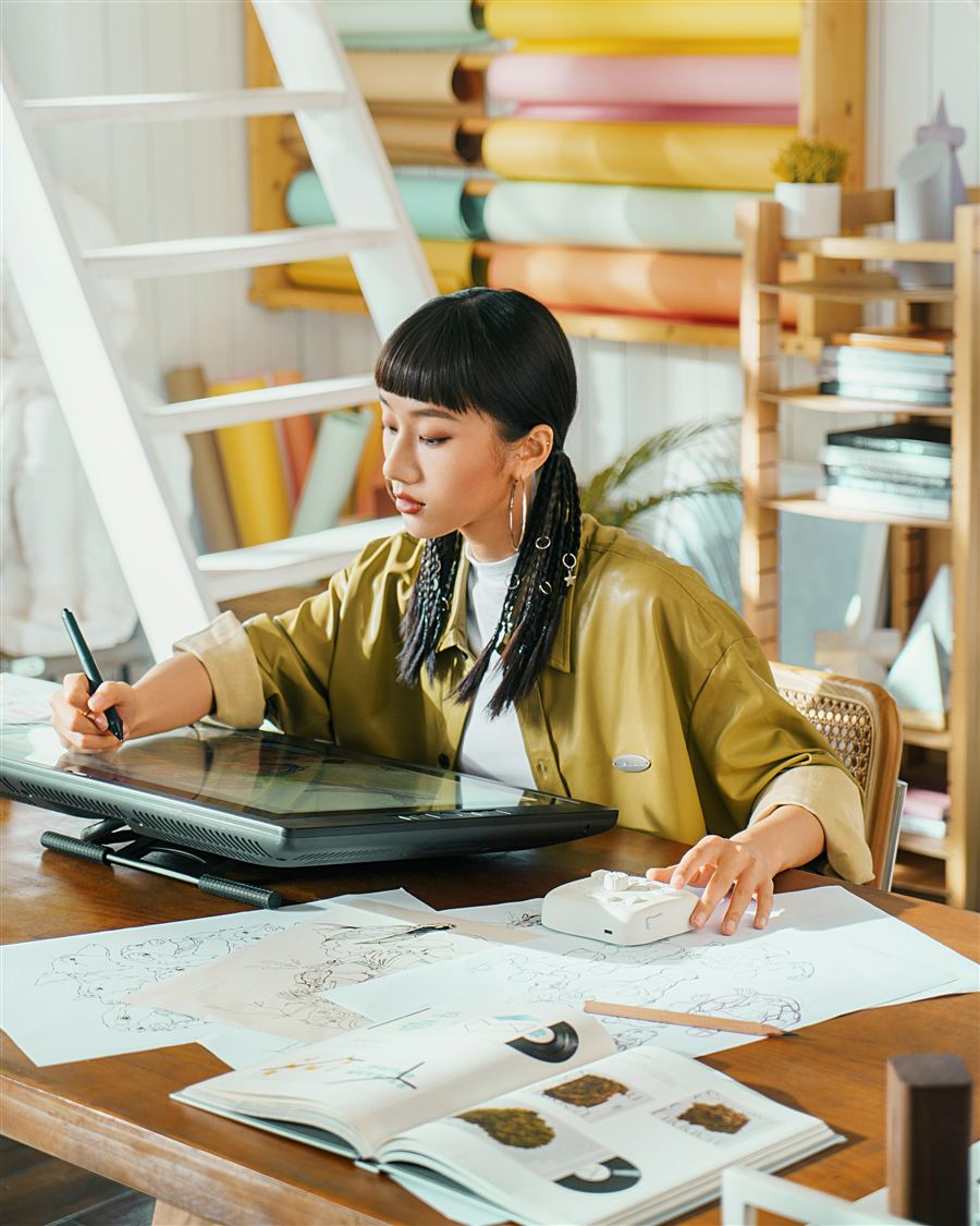A freelance illustrator working on a digital drawing tablet