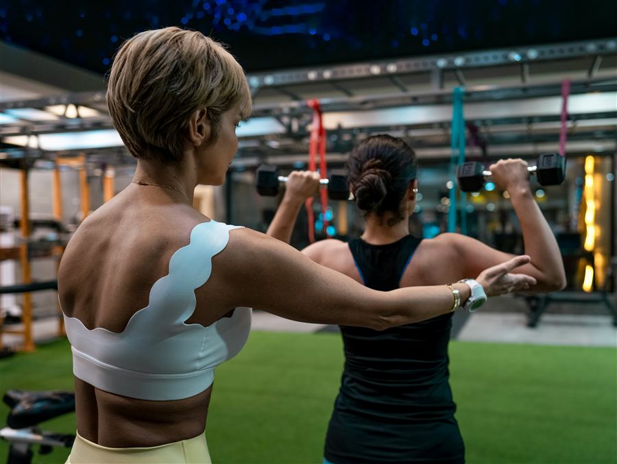A health and wellness practitioner guiding a client through an exercise