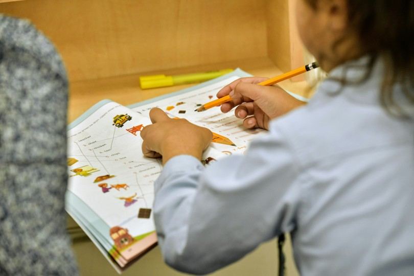 A student working through a worksheet with a tutor