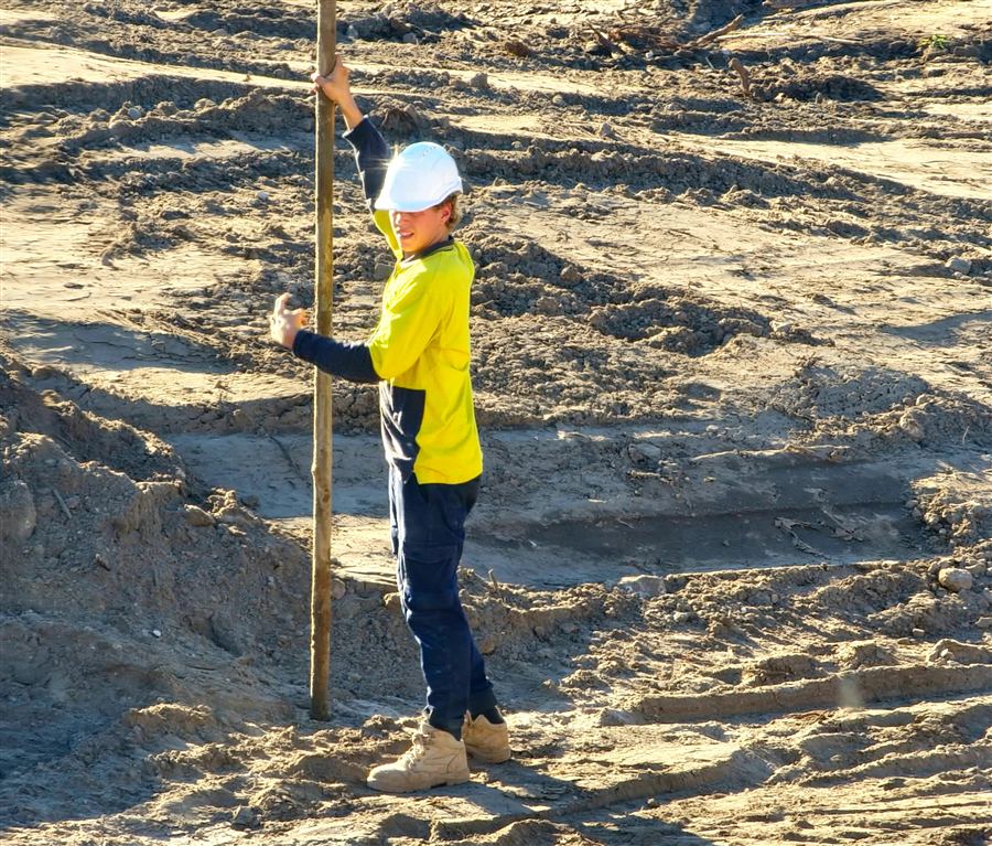 A tradie on site wearing high-vis and a hard hat